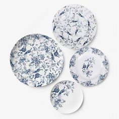 four plates with blue and white designs on them