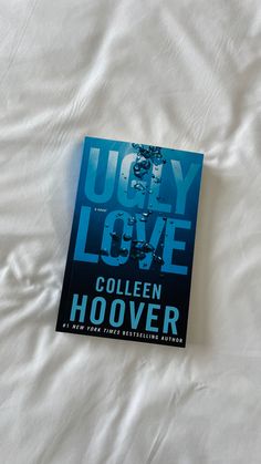 the book ugly love by collien hoover is laying on a white sheet