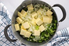 a pot filled with diced onions and cheese on top of a blue and white towel