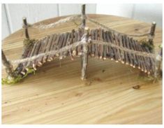 a piece of wood sitting on top of a wooden table covered in grass and twigs