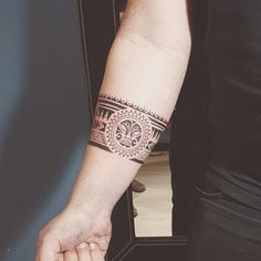 a man with a tattoo on his arm holding the hand of another person's wrist