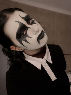 a woman with black and white makeup on her face