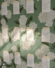 there are many cards attached to the wall with flowers and leaves on them, all pinned together