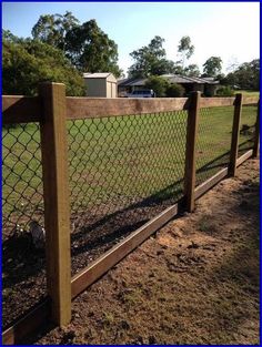 an image of a fence that is in the middle of some dirt and grass area