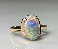 an opalite ring is shown on a white surface with gold trimmings