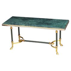 a green marble topped table with brass legs