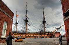 two people standing in front of a large ship