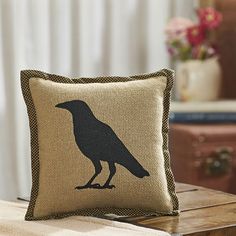 a pillow with a black bird on it