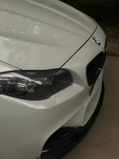 the front end of a white bmw car