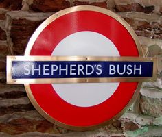 there is a sign that says shepherd's bush on the side of a brick wall