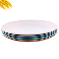 four plates stacked on top of each other in front of a wheat stalk and rice