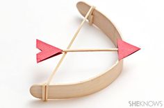 a wooden bow and arrow brooch on a white background