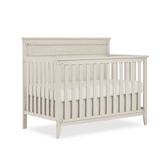 a white crib with no mattress in the middle and side rails on each end