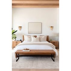 a bed with white sheets and pillows in a bedroom next to a wooden ceiling light