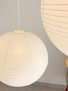 two white paper lanterns hanging from the ceiling