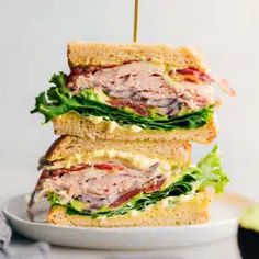 two sandwiches stacked on top of each other with meat and lettuce in the middle