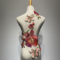 a white mannequin with red and pink flowers on it's back side