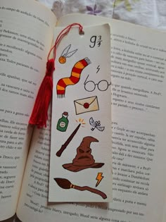 an open book with some harry potter stickers on it's cover and a red tassel