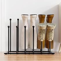 several pairs of shoes are lined up on the floor in front of a radiator