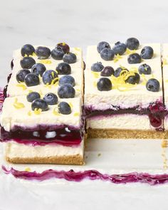 there are four slices of cake with blueberries on top