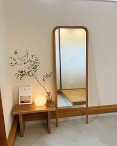 a wooden table with a vase and mirror on it