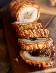 sliced meatloaf sitting on top of a wooden cutting board