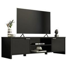 an entertainment center with a large flat screen tv on it's stand and a plant next to it