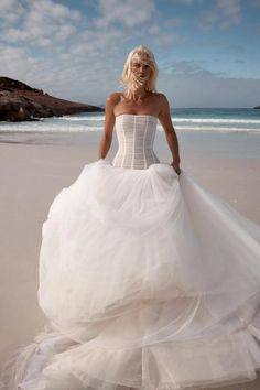 a woman in a wedding dress on the beach