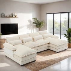 a living room with a large white sectional couch in front of a flat screen tv