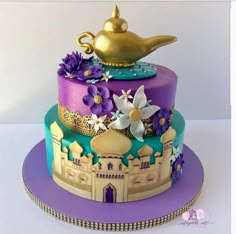 there is a purple and blue cake with flowers on it's tiered tower