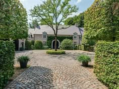 a large brick driveway surrounded by trees and bushes