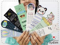 a woman holding up several different bookmarks in her hands with the caption's name on them