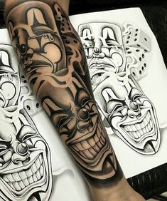 a man's arm with some tattoos on it and two clown masks in the background