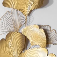 three gold leaf sculptures on a white wall