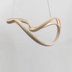 a wooden light fixture hanging from a string in a white room with no one around it