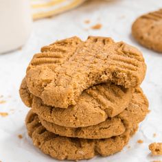 a stack of peanut butter cookies next to a glass of milk