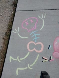 a sidewalk with chalk drawings and crayons on it