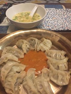 dumplings with sauce in a silver bowl on a table