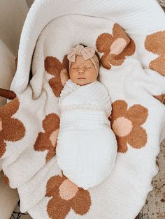 a baby wrapped in a blanket on top of a bed