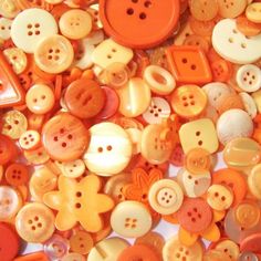 many orange and white buttons are scattered together