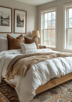 a large bed sitting next to two windows in a bedroom on top of a rug