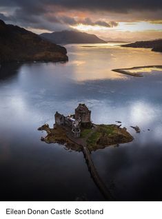 an island in the middle of water with a castle on it's side at sunset