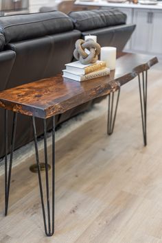 a wooden table sitting on top of a hard wood floor next to a black couch