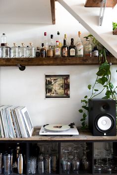 the shelves are full of liquor bottles, books and other things in front of them