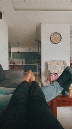 a person is sitting on the couch with their feet up in front of the camera