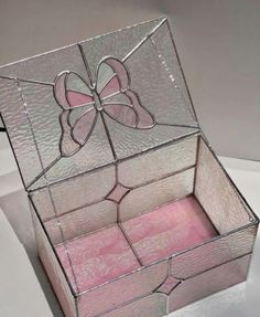 a pink and white box sitting on top of a table next to a mirror window