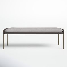 the bench is made from metal and has a light gray upholstered cushion on it