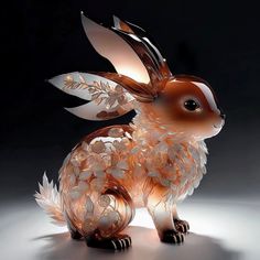 a glass sculpture of a rabbit with leaves on its body and tail, sitting in front of a black background