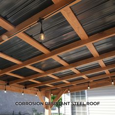 a wooden pergolan with lights hanging from it's sides and the words corrosion resistant steel roof