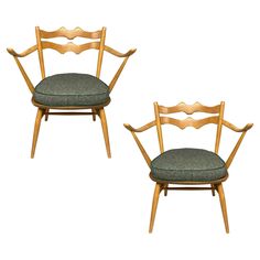 two wooden chairs with green upholstered seats on each side and one in the middle